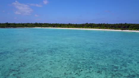 Ruhiges-Meer-Mit-Klarem-Wasser-Und-Riff-Auf-Den-Malediven,-Resort-Am-Strand-In-Der-Ferne