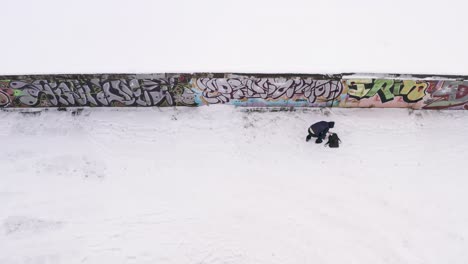 person near a graffiti wall covered in snow