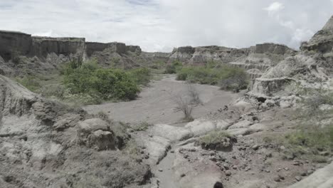 Couple-Hikers-Walking-Through-The-Arid-Landscape-Of-Tatacoa-Desert-In-Huila,-Colombia---drone-shot