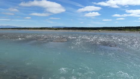 Steadily-flowing-water-crosses-channels-in-beautiful-turquoise-colored-river-in-summertime