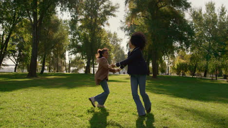 hija alegre jugando a la madre juntos en el parque soleado. feliz fin de semana familiar