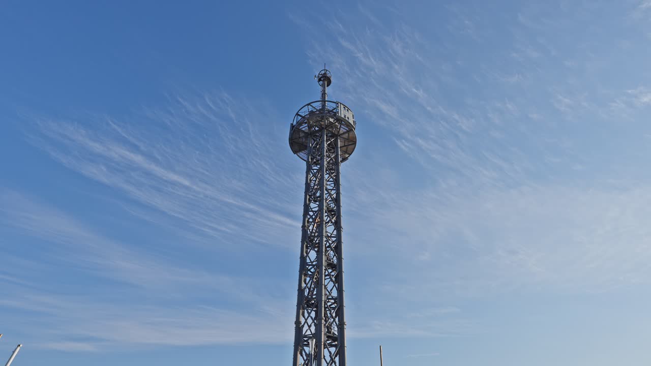 Aufnahme der hohen, vergitterten Metallstruktur des Harumi Port-Signalturms aus niedrigem Winkel vor einem strahlend blauen Himmel