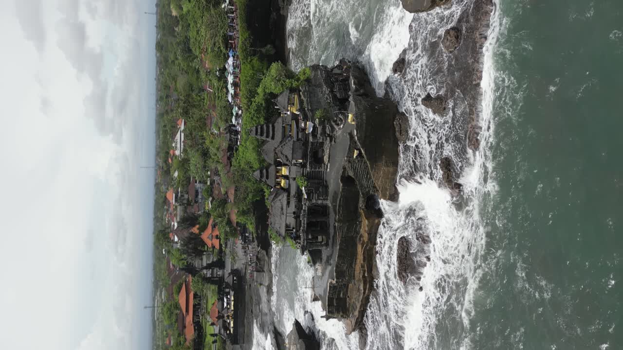 Sorvolo in formato verticale del Tempio di Tanah Lot su uno sperone roccioso nell'oceano, Bali
