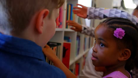 schoolkids selecting a book in a library at school 4k