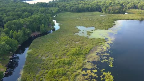 4K-Luftüberflug-Eines-Malerischen-Kanals-Und-Sees-Mit-Blauem-Wasser,-Grünen-Bäumen-Und-Sonnigem-Sommerwetter