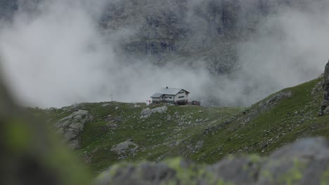 incredible scene of chalet house on top of mountain hill, seen through rocks