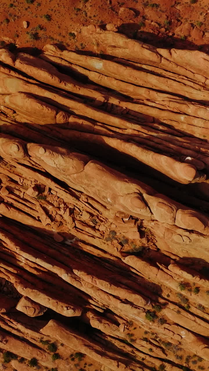 Fascinating rocks of Arches canyon cut like plates by the wind. Highway with a car moving by beside the mountains. Top view. Vertical video