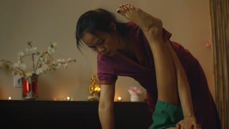 terapeuta que da un masaje tradicional chino de los pies. terapeuta profesional que da un masaje tradicional chinés de los pies a una mujer en un terapéutico chino