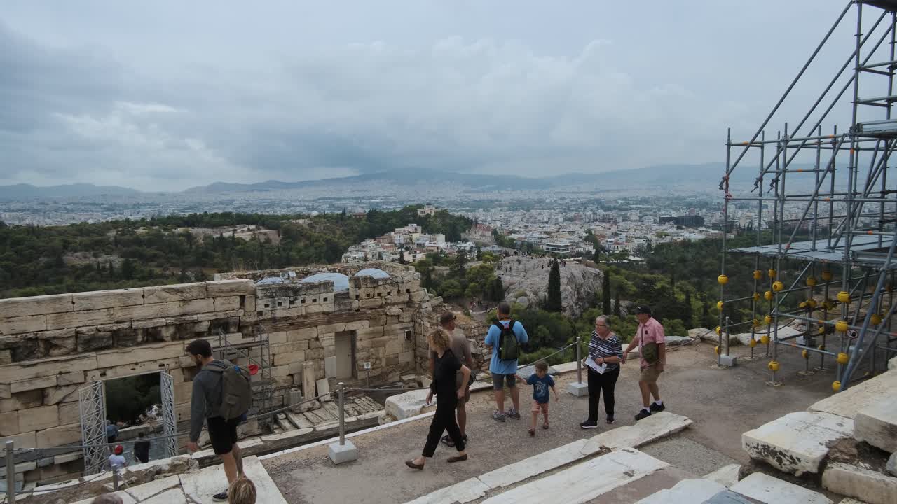 Athens, Greece - October 12, 2021: A crowd of tourists storm the Acropolis after its opening. Propylaea gateway in background