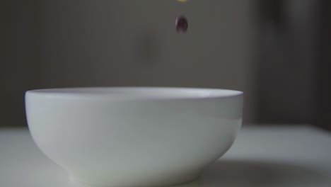 candy being poured into white bowl, slow motion