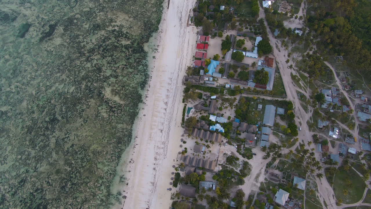 volando sobre bungalows de lujo en la exótica isla de zanzíbar, a lo largo de la costa y la salida del océano