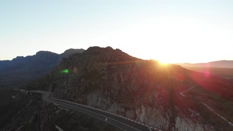 Eine-Kippende-Drohne,-Die-Bei-Sonnenuntergang-Auf-Einer-Bergigen-Straße-Geschossen-Wurde