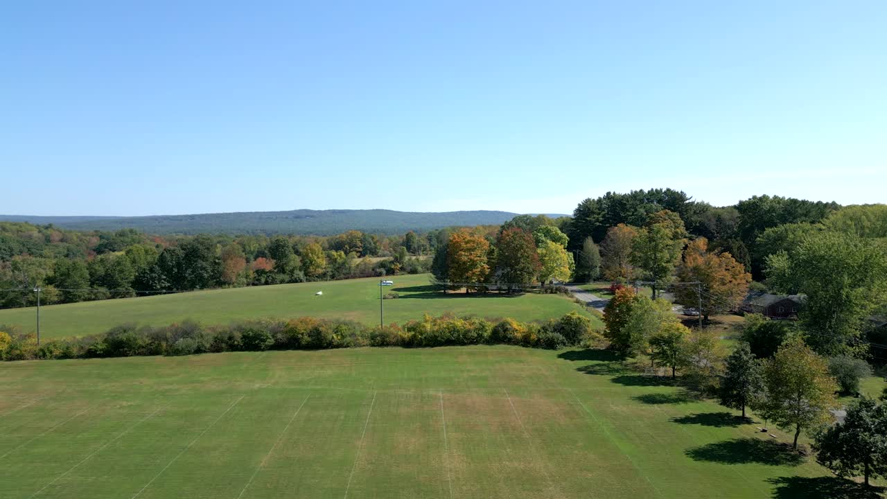 Drone fly at countryside meadow with trees on open grassy area at Groff Park in Amherst, Massachusetts, USA