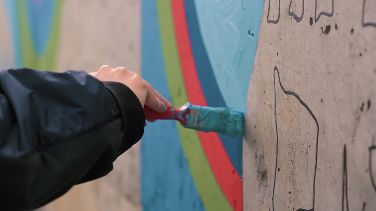 벽에 다채로운 벽화를 그리는 사람