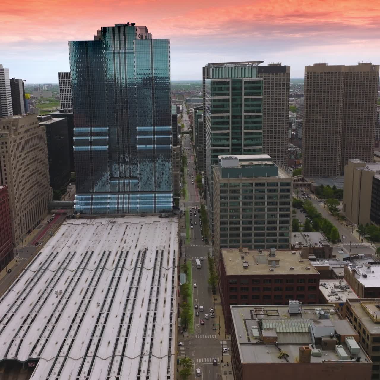 Rows of beautiful modern buildings of stunning Chicago, Illinois. Drone footage over subway depot. Pink sky at backdrop