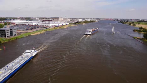 barcazas de carga interiores navegando en el río oude maas durante el día en la zona de zwijndrecht, países bajos