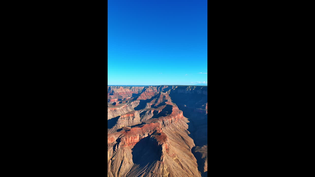Sunlit panorama of spectacular rocks against blue sky. The Grand Canyon National Park, Arizona, USA. Vertical video