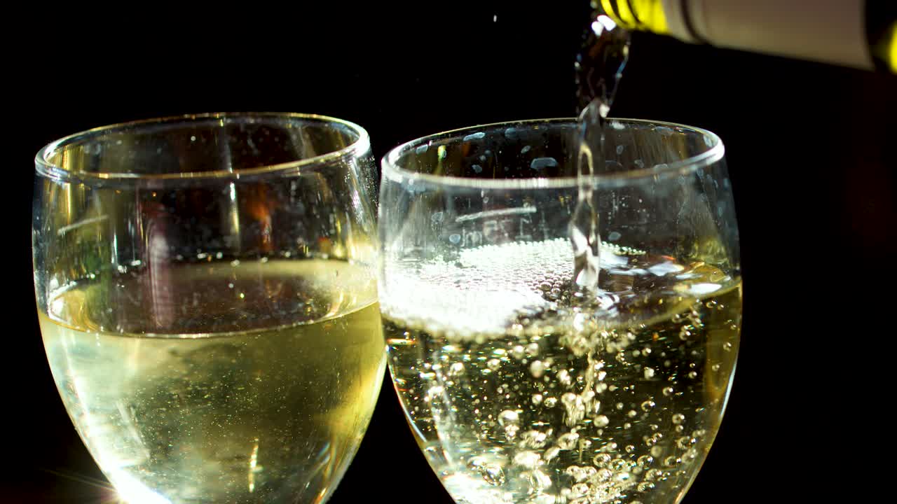 Sparkling drink poured into clear wine glass, bubbles rising, dark background, strong side lighting