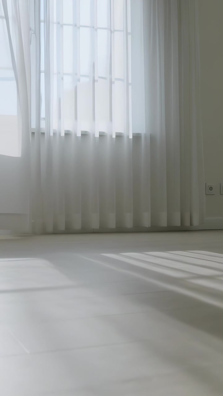 Video verticale: Una folata di vento fa ondeggiare tende trasparenti, ombre che si spostano sul pavimento vicino alle sbarre della finestra, una presa di corrente.