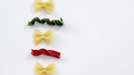 various pasta arranged in a row on white background