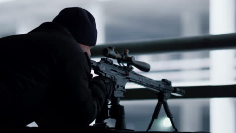 Hitman-shooting-with-sniping-rifle.-Serious-killer-targeting-scope-on-weapon