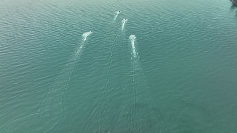 Vista-Aérea-De-Las-Carreras-De-Jetskiers-En-Las-Tranquilas-Aguas-Azules-Del-Mar-En-Verano