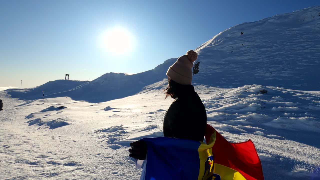 Girl walking with a Romanian Flag on top of The Bucegi Mountains in Romania - slow motion shot