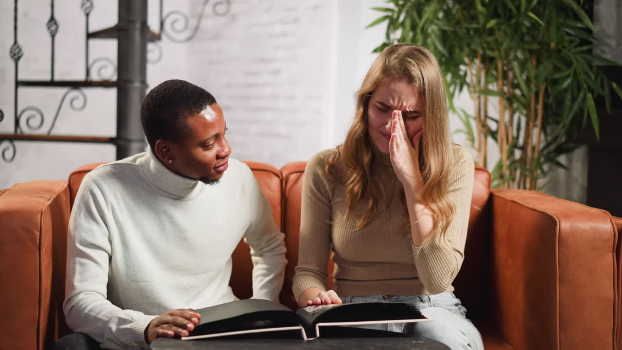 mujer cuenta historias de familia a un amigo hombre negro en el álbum
