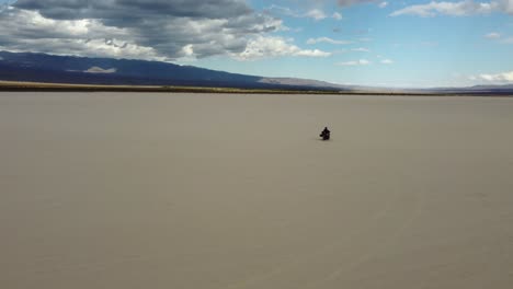 motociclista viaja a través de la llanura de arena pampe del leoncito en argentina