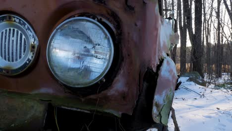 primo piano vecchia macchina arrugginita in un bosco innevato