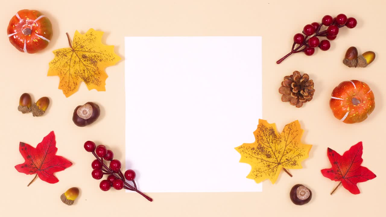 Autumn leaves and fruits move around white paper for text. Stop motion
