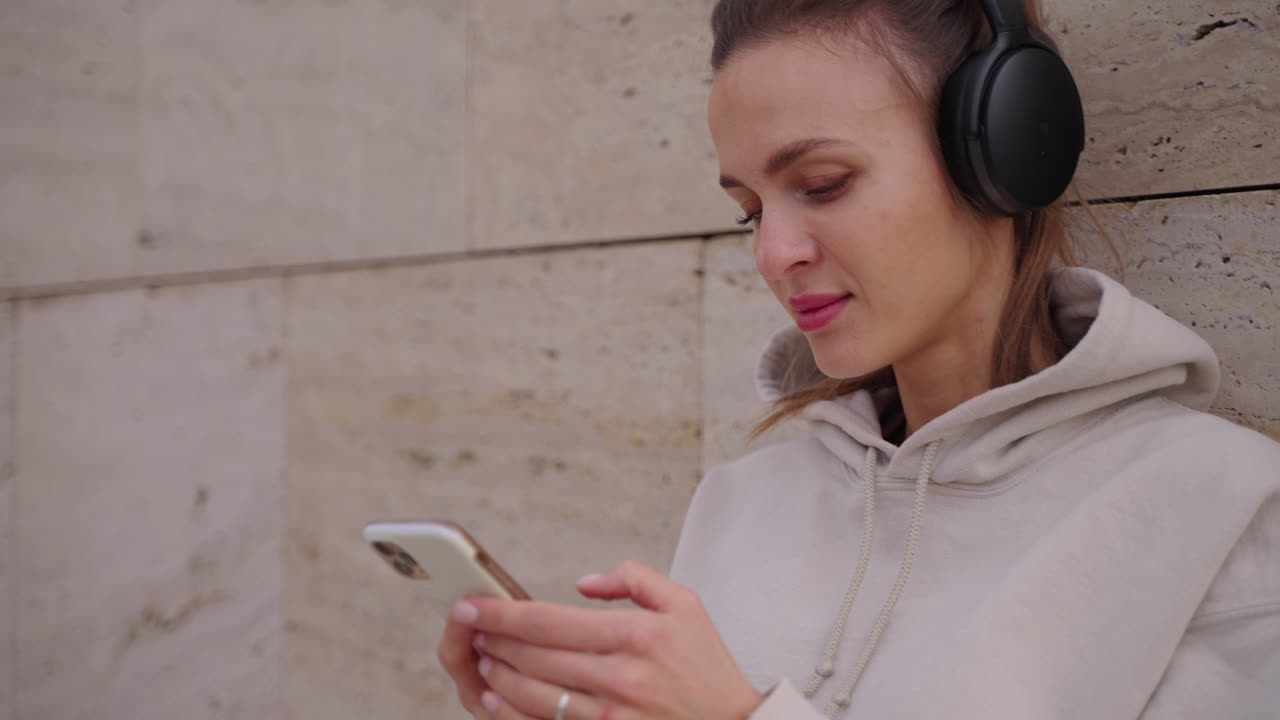 mujer usando un teléfono inteligente y escuchando música al aire libre