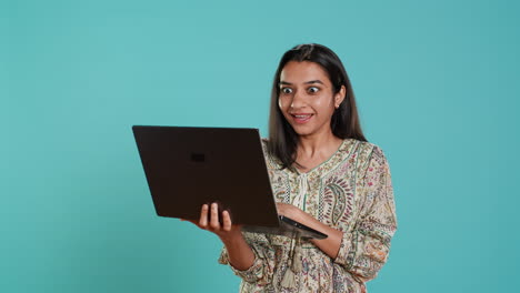 Upbeat-woman-saluting-coworkers-during-teleconference-meeting-using-laptop