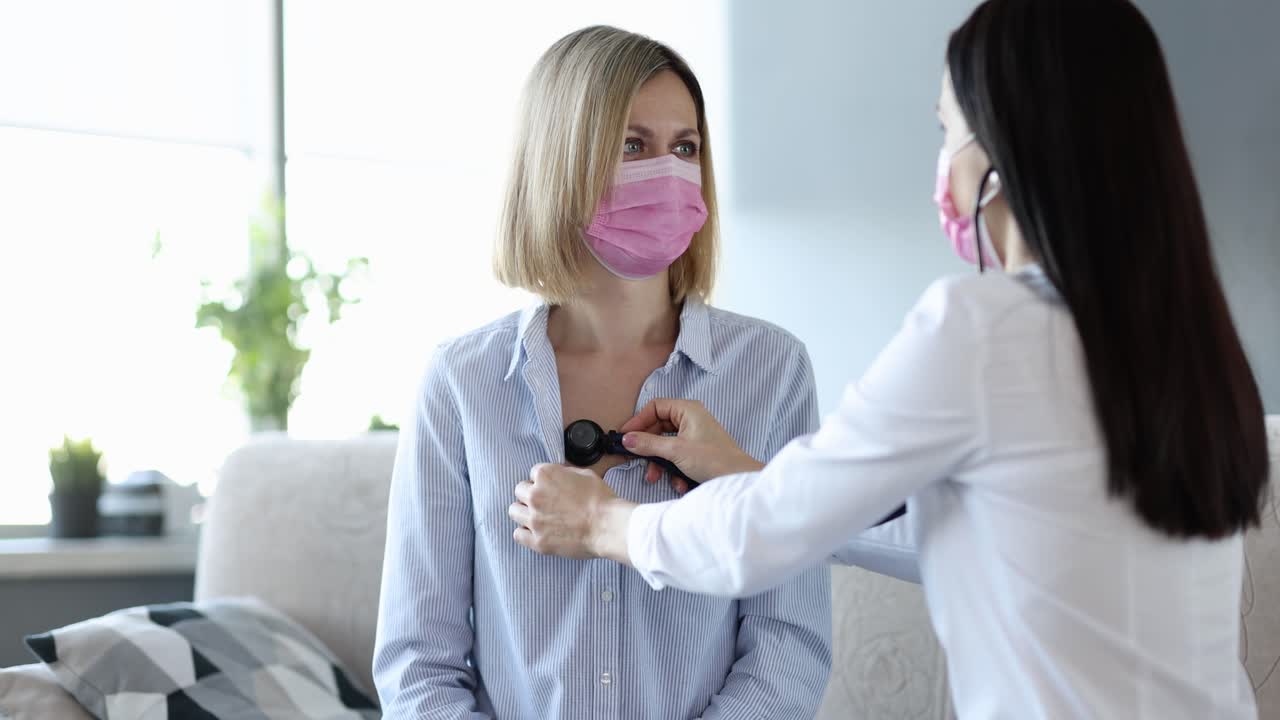 Doctor examining patient with stethoscope and face masks