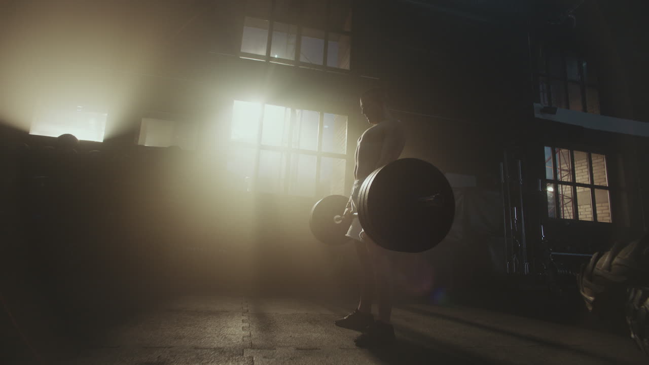 мужчина поднимает штангу в тренажерном зале