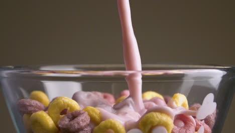 flakes with milk. stock footage. close-up in multi-colored sweet flakes add milk. milk with sweet multi-colored rings. harmful sweet food