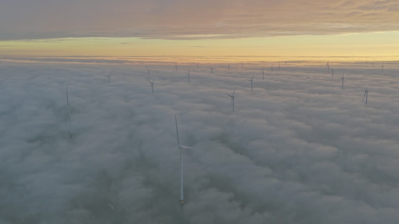 Havvindmøller ved solopgang under lave skyer, der producerer bæredygtig energi.