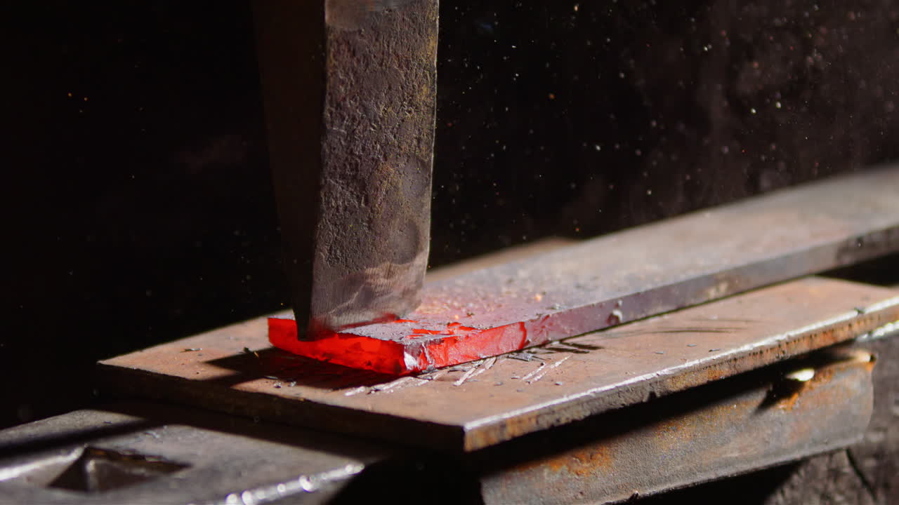 An iron bar to be split in two by a blacksmith in the smithy. 240fps slow motion