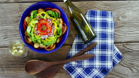 ensalada con vino en una mesa de madera