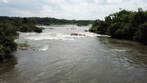 Vista-Aérea-De-Drones-Alejándose-De-Los-Botes-De-Rafting-Que-Bajan-Por-El-Río-Nilo-En-Jinja,-Uganda,-áfrica