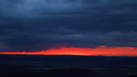 dark red clouds during sunset open in the gap between the clouds and the horizon