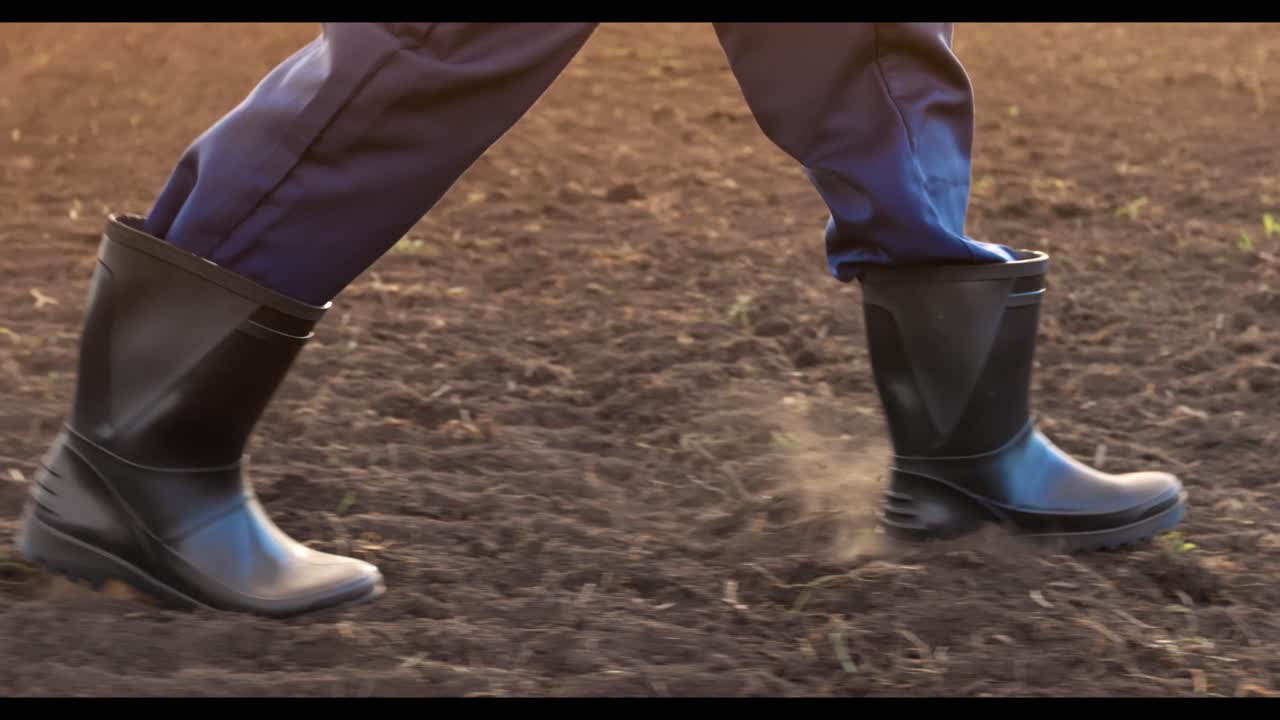 Person walking in a field in rubber boots
