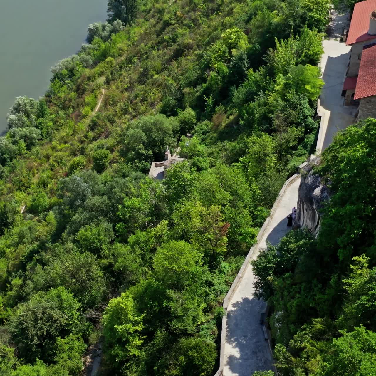Aerial view on the tower of the castle located on a top of a hill. Beautiful river flows below. Selective focus on video