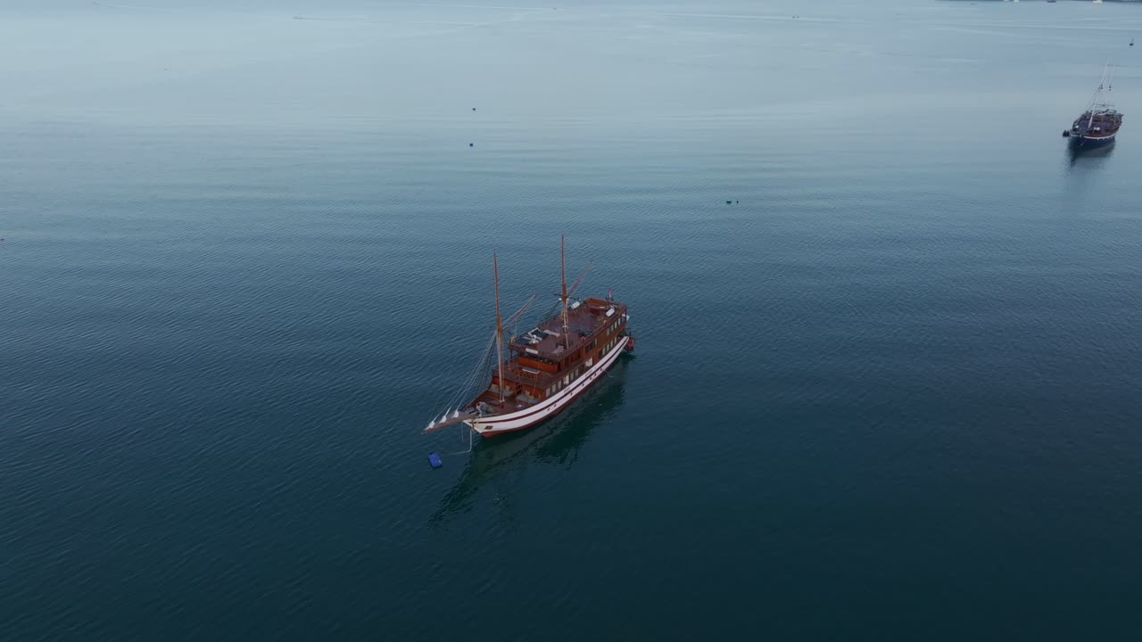Kapal wisata kecil berlabuh di air tenang, Labuan Bajo, Flores, Indonesia