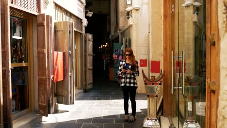 girl texting and talking to smartphone in arabian souq