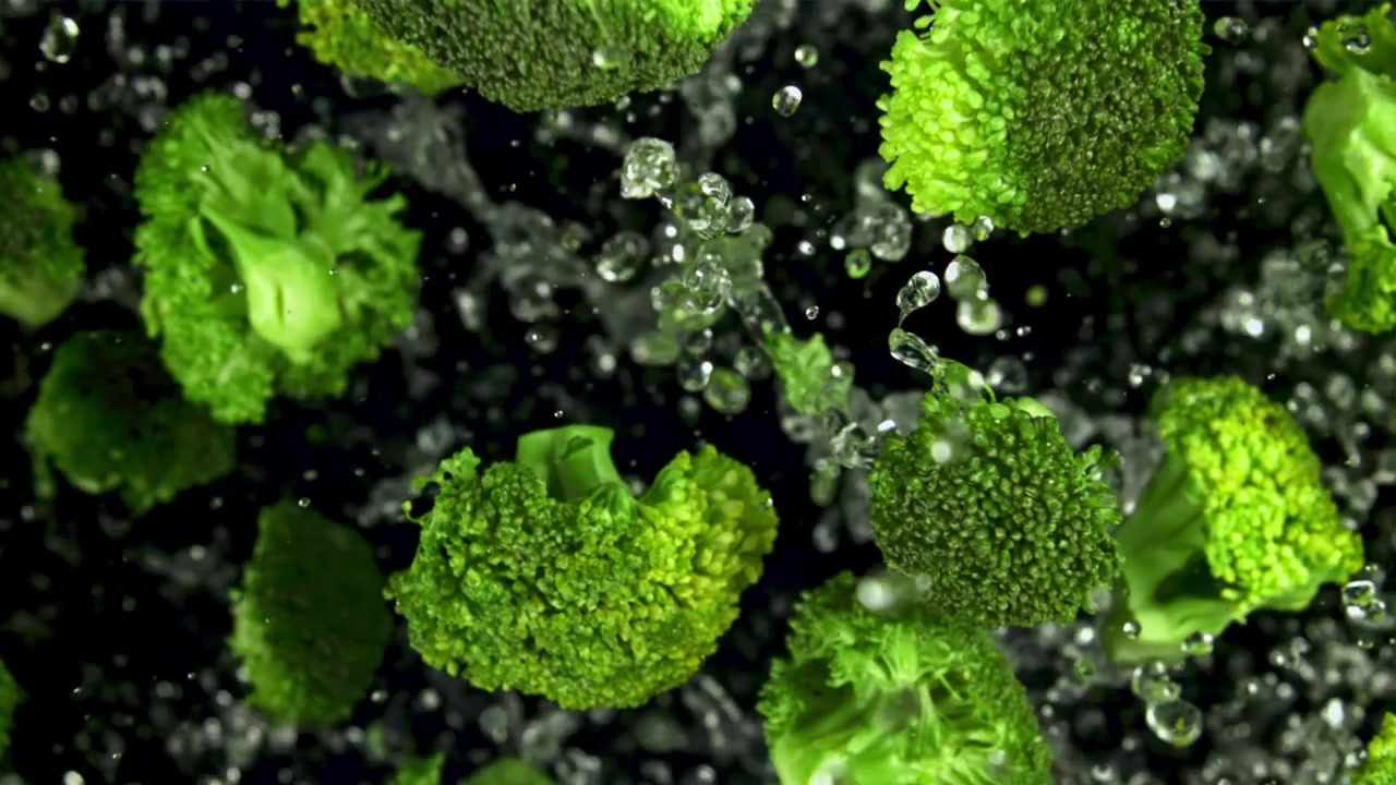 Cimette di broccoli freschi e verdi con schizzi d'acqua al super rallentatore