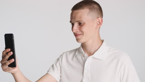 blond man doing a videocall with his smartphone