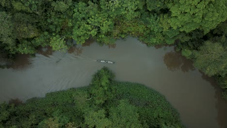 Top-View-Of-A-Sailing-Wooden-Boat-On-A-Calm-River-In-Tropical-Forest