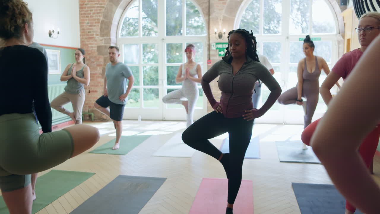 Group yoga class practicing tree pose