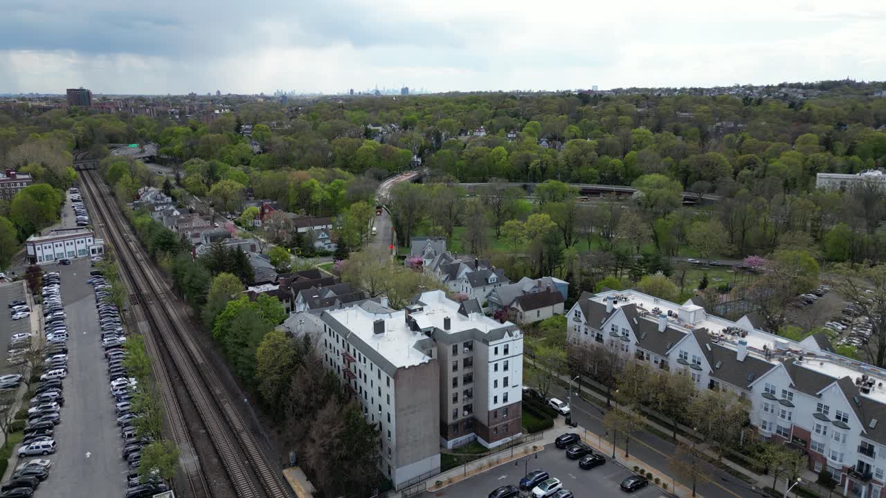 Horizontal drone footage showing a smooth descending shot over Bronxville, New York. Captures a scenic view of the suburban landscape, tree-lined streets, and residential areas.